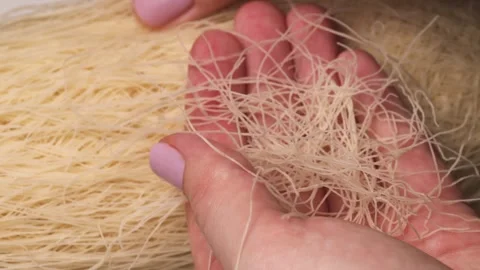 Hands picking up raw kataifi dough with delicate shredded phyllo Stock Footage 300997893