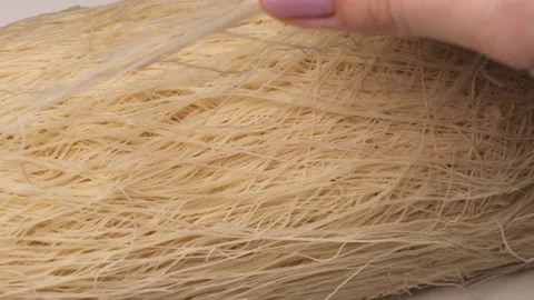 Hands picking up raw kataifi dough showcasing delicate shredded phyllo stra.. Stock Footage 300998007