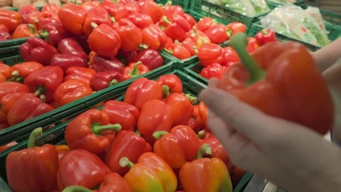 Hands picking red bell pepper in a grocery store Stock Footage 333874629