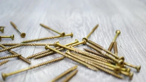 Hands picking up screws that are on the floor Stock Footage 246841184