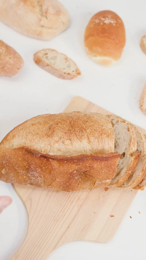 Hands Picking Up Sliced Sourdough Bread on Wooden Board Stock Footage 337690946