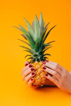 Hands with pineapple on bright yellow Stock Photos