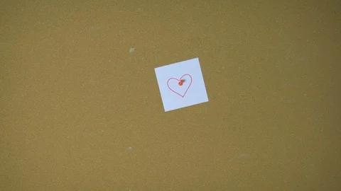 Hands pining heart on sticky note on pin board funny animation Stock Footage 98849782