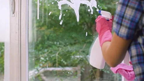 Hands in pink gloves cleaning windows with a detergent spray foam and rag. 스톡 동영상 140615200