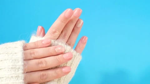 Hands with pink manicure on blue background top view close-up. Stock Footage 221379561