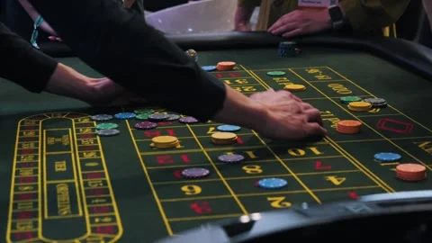 Hands place chips on numbered casino betting table with clear marker, scattered Stock Footage 344793761
