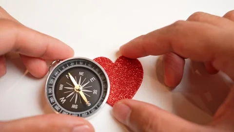 Hands place a compass and a heart together. Stock Footage 317600163