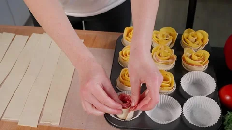 Hands place ready-made dough roses into a muffin tin. Stock Footage 255407514
