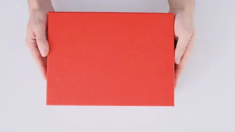 Hands place red box on table and open the lid. Empty box with green bottom 库存影片 172485212