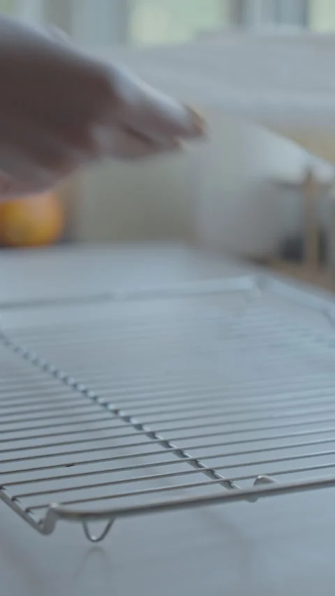Hands place wire rack on table and cover it with parchment paper for baking Stock Footage 339632652