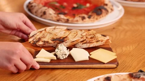 Hands Placing a Cheese Board and Toasted Bread on a Restaurant Table Video stock 338420255