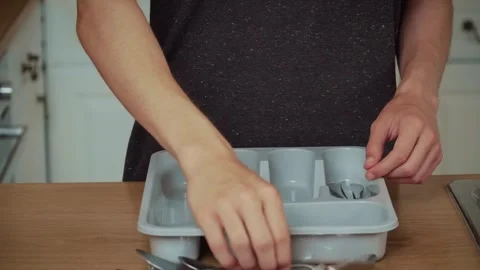Hands placing fork into plastic organizer. Unrecognizable person sorting cutlery Stock Footage 316307294