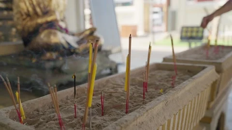 Hands placing incense sticks while making wishes and worshipping a Buddha statue Stock-Footage 328492108