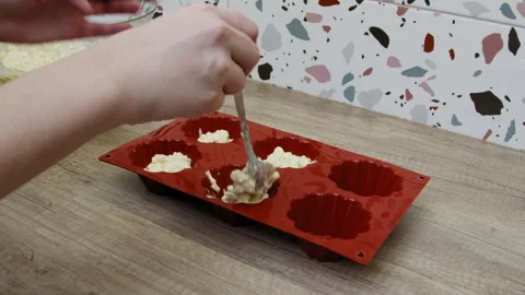 Hands placing ingredients into a muffin pan. Stock Footage 266425278