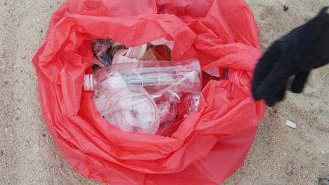 Hands placing plastic into a trash bag. Stock Footage 308446402