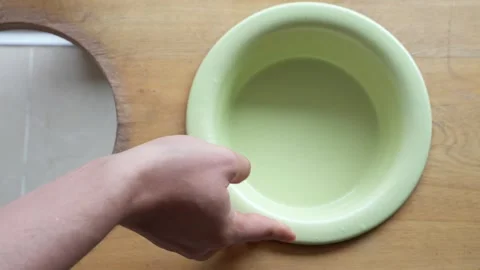 Hands Placing Red and Green Pet Bowls in Wooden Holder After Cleaning Stock Footage 291703851