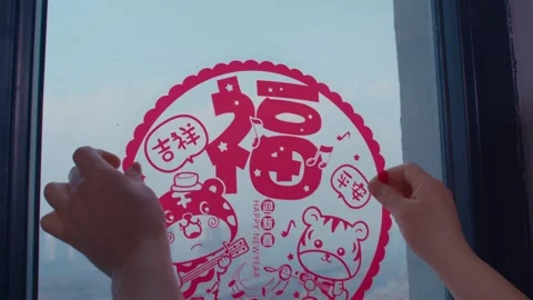Hands Placing Red Lunar New Year Tiger Window Decal on Glass Stock Footage 336547429