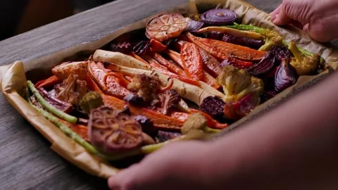 Hands Placing Roasted Vegetables Tray on Wooden Table Close Up Stock Footage 334338183