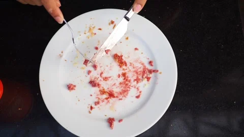 Hands placing silver fork and knife on empty white plate with leftover red .. Stock Footage 332202288