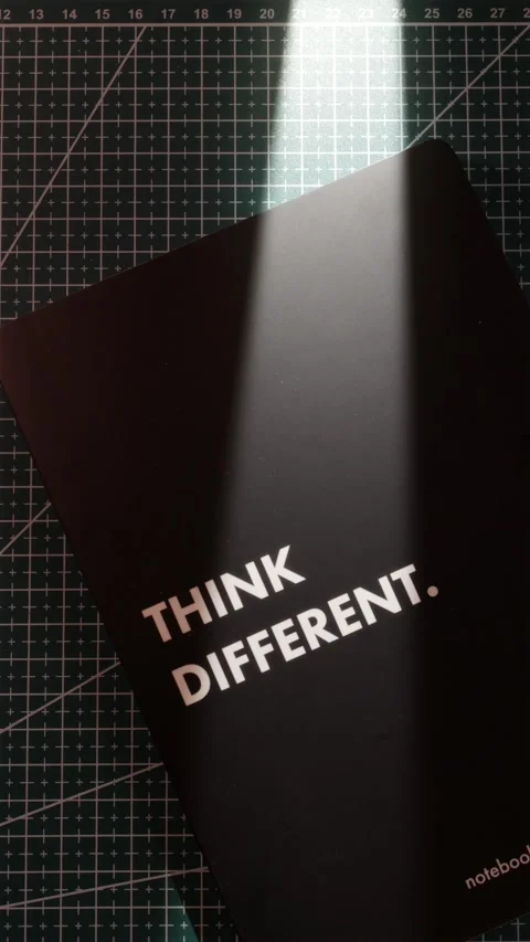 Hands placing Think Different motivational notebook on desk vertical Stock Footage 340139091