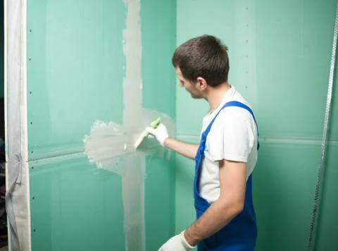 Hands plasterer at work. Application of the plaster on the wall Stock Photos