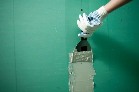 Hands plasterer at work. Application of the plaster on the wall Stock Photos