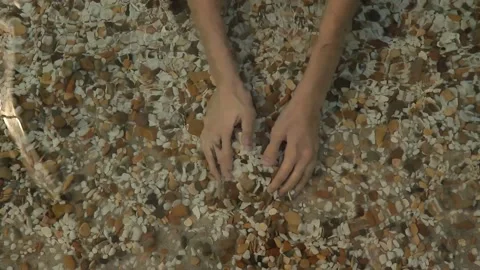 Hands play out pebbles in the water. beach games Stock Footage 201129607