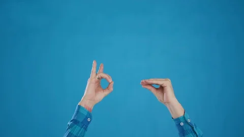 Hands play pantomime on blue background close-up 4K frame Stock Footage 127625435