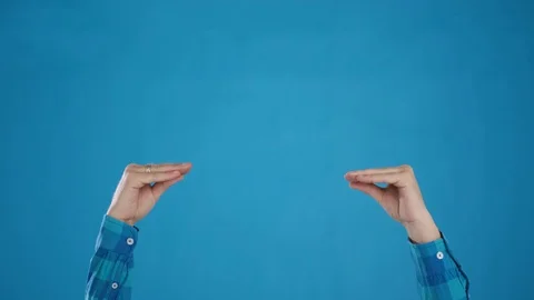 Hands play pantomime on blue background close-up 4K frame Stock Footage 127625470