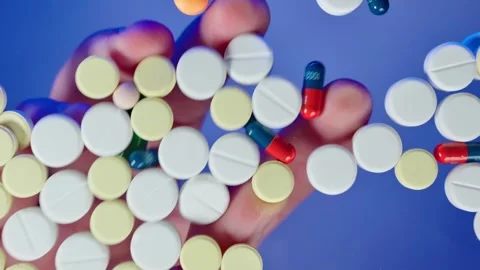 Hands play with pills scattered on the table Stock Footage 267421513