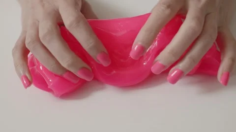 Hands play with pink slime in a bright space during daytime Stock Footage 341507702
