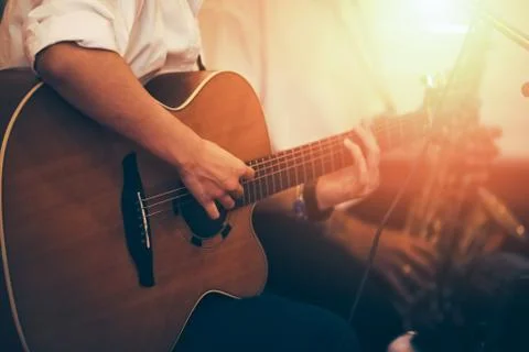 Hands playing acoustic guitar on the stage, close up Stock Photos