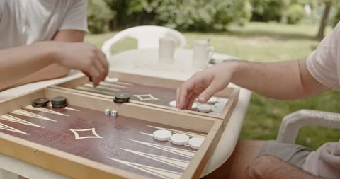 Hands playing backgammon in a park setting, capturing the essence of leisure Stock Footage 281577671