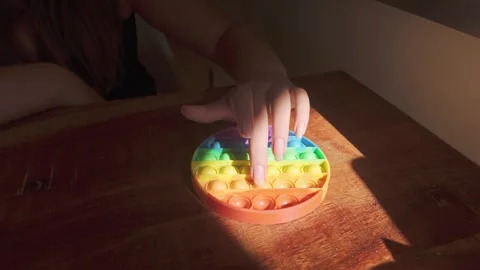 Hands Playing with Colourful Pop-It and Squishy Balls Sensory Fidget Toys Stock Footage 346849431