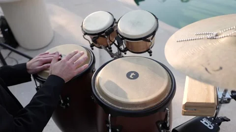 Hands playing conga and bongo drums in rhythmic motion outdoors Stock Footage 320667059