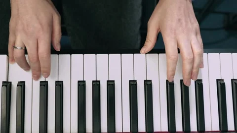 Hands playing digital piano keys, top view. Musician fingers pressing black and Stock Footage 303523739
