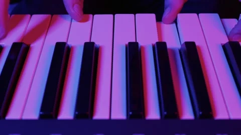 Hands Playing Electronic Piano Keyboard in Neon Lights Stock Footage 325880282