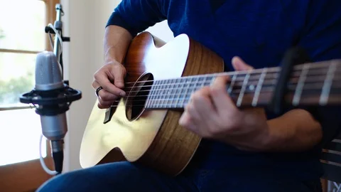 Hands Playing Guitar in front of Microphone in Home Recording Studio Stock Footage 112662661