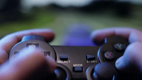 Hands playing racing game joystick, controller or joypad on blurred screen  Stock Footage 231202764