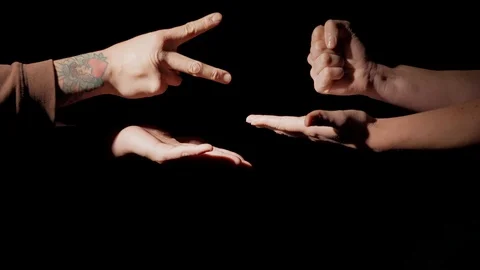 Hands playing rock paper scissors black background Stock Footage 122548169