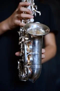 Hands playing a silver saxophone Stock Photos