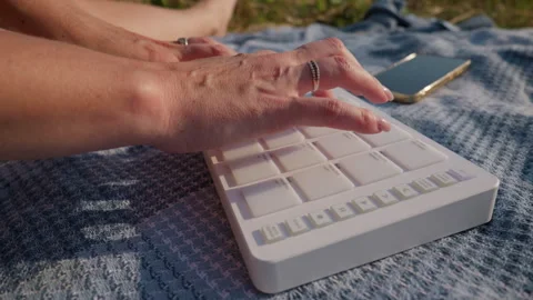Hands Playing White Midi Drum Pad Controller Outdoors in Sunlight Stock Footage 342770557