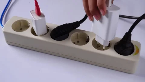 Hands plugging charger into power socket on table Stock Footage 275872371