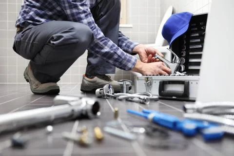 Hands plumber at work in a bathroom, plumbing repair service, assemble and in Stock Photos