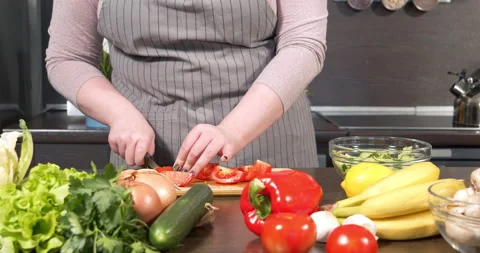 Hands of a plus size young woman preparing fresh vegetable salad in the kitchen Stock Footage 149106920