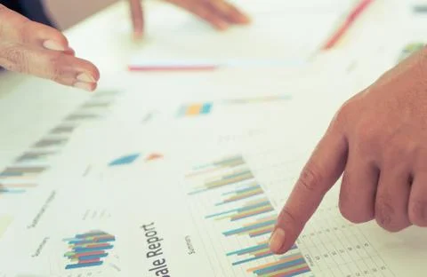 Hands pointing on data chart sheet for business meeting Фото