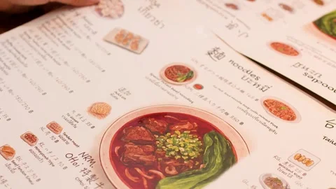 Hands Pointing at Menu Ordering Food in Asian Restaurant Stock Footage 345099838