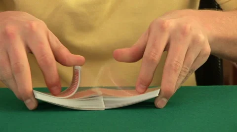 Hands on a poker table shuffling a deck of cards and dealing Stock Footage