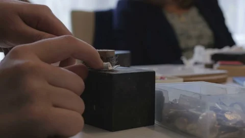 Hands polishing silver clay jewelry Stock Footage