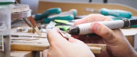 Hands Polishing a Small Metal Object with a Rotary Tool at a Workbench Vídeo Stock 342562951